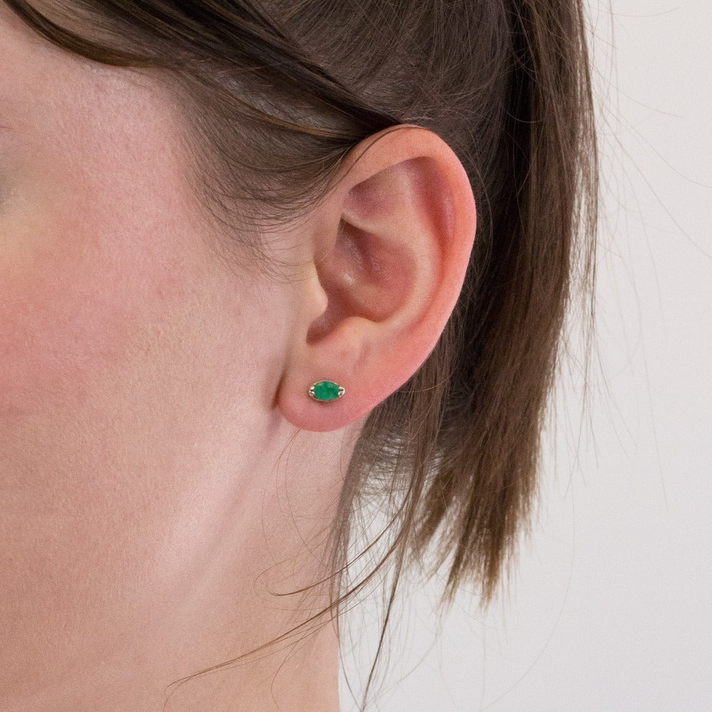 Emerald stud earrings on model