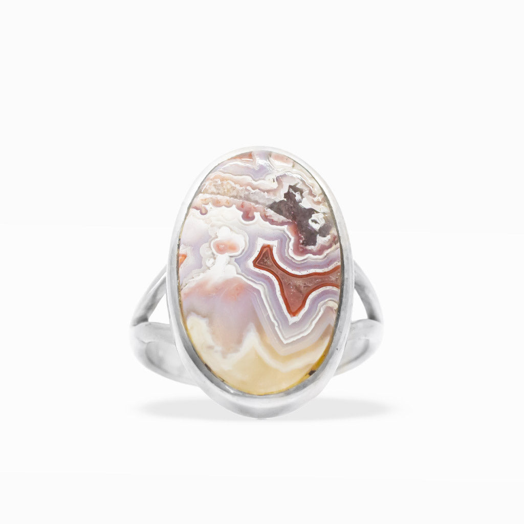 Oval Crazy Lace Agate ring with intricate cream, lavender, peach, and red banding in polished sterling silver bezel setting.