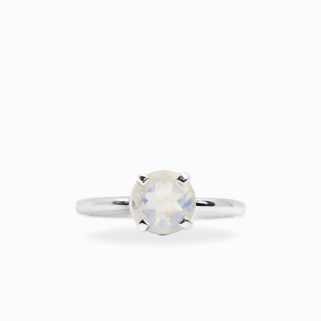 Round faceted Rainbow Moonstone ring in polished 925 sterling silver with blue flashes, four-prong setting and slender band.