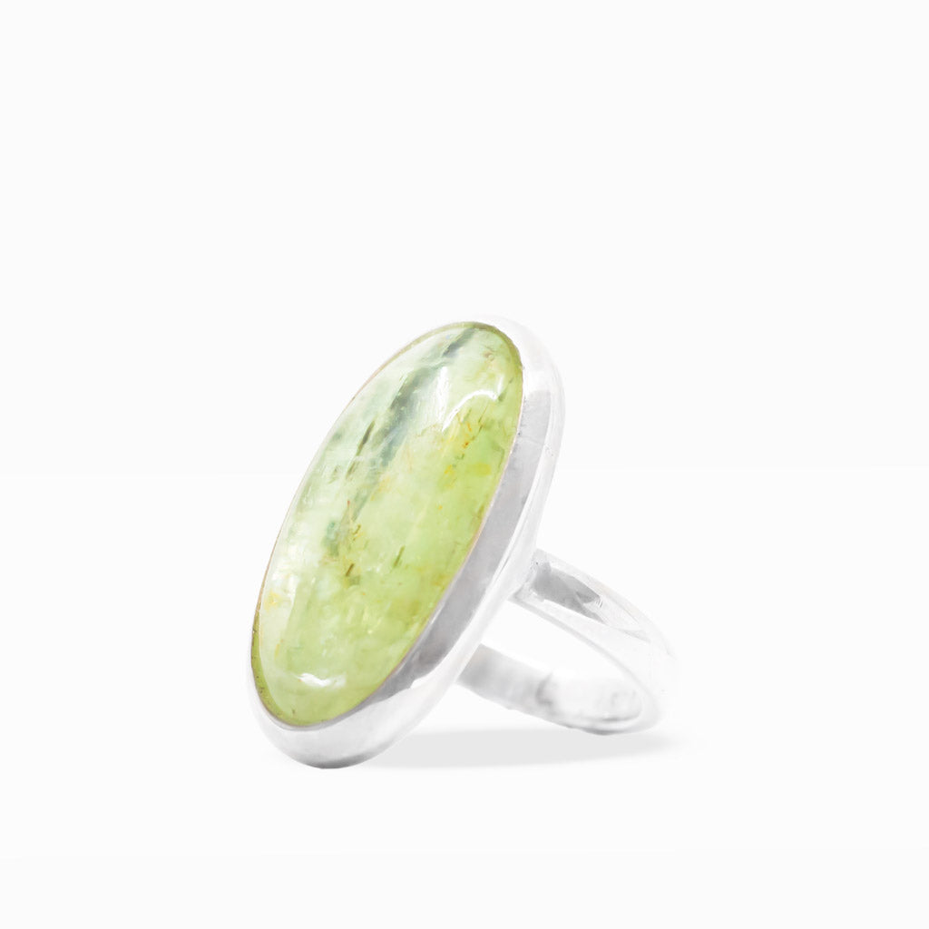 Pale green translucent oval Green Kyanite cabochon ring with natural inclusions, sterling silver bezel, and split band.