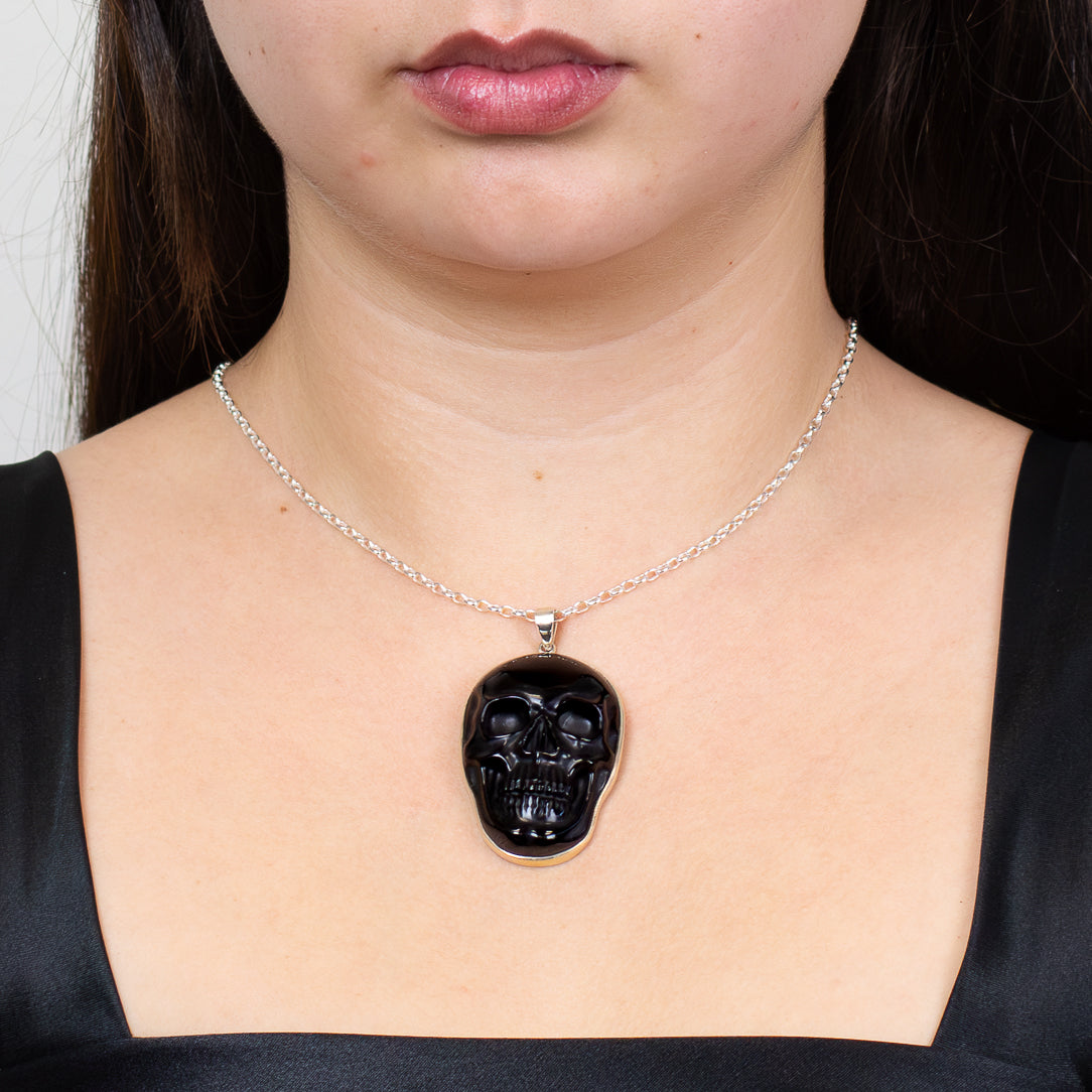 Black obsidian skull pendant in sterling silver on chain on model. MADE IN EARTH