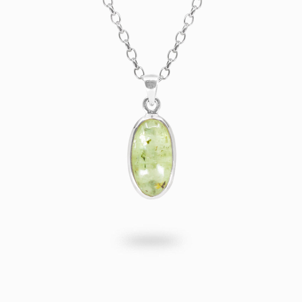 Elongated oval pale-green Kyanite cabochon pendant with natural inclusions in a polished 925 sterling silver bezel setting.
