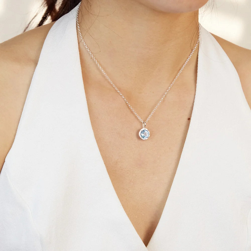 Round faceted sky-blue Blue Topaz gemstone set in polished sterling silver pendant necklace.