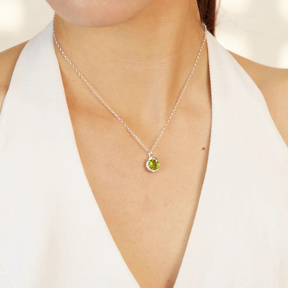 Round faceted bright green Peridot gemstone set in polished sterling silver pendant necklace.