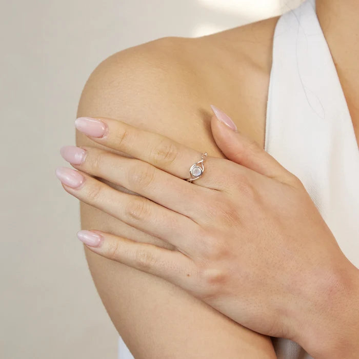 Round faceted Rainbow Moonstone gemstone in polished sterling silver eye design ring.