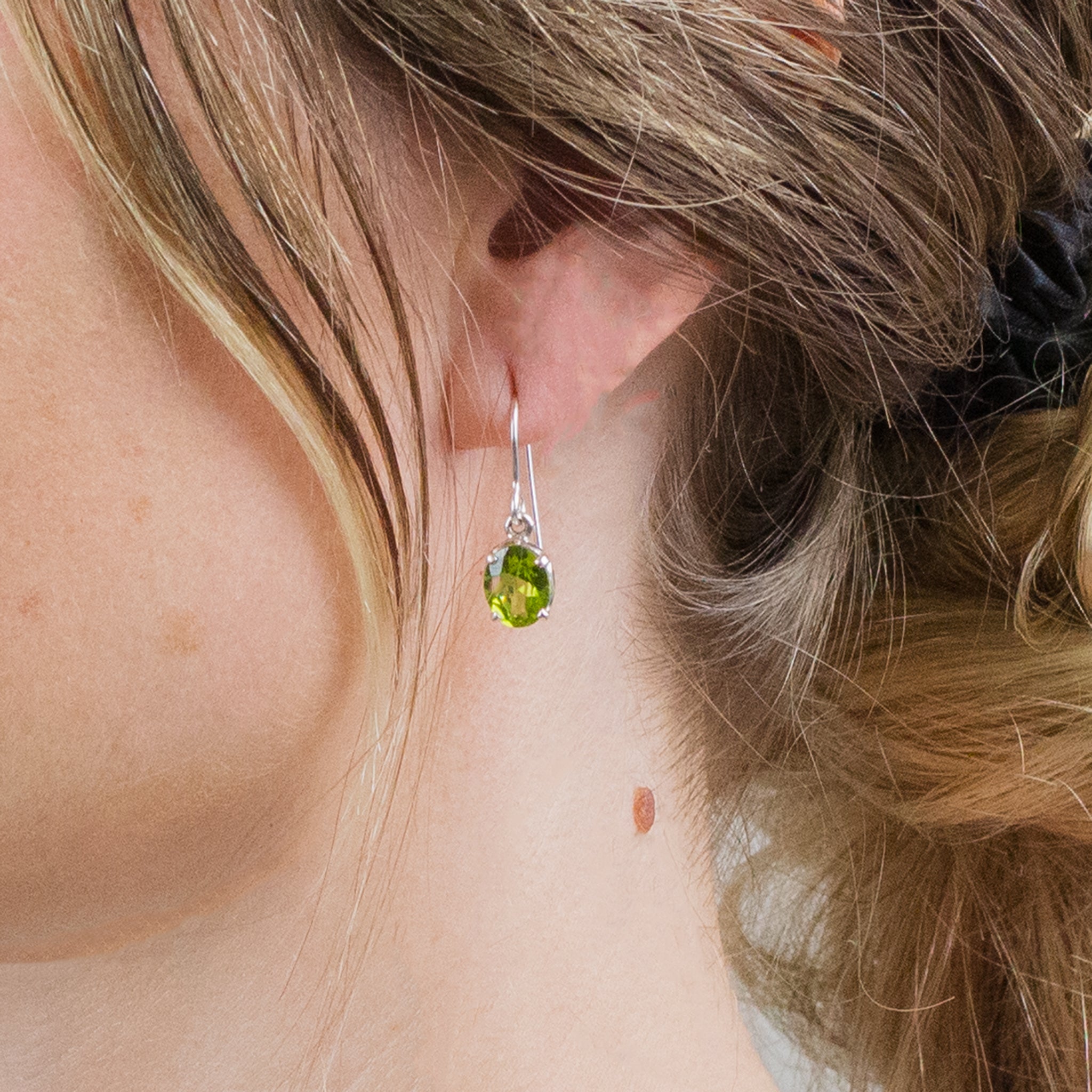 FACETED OVAL PERIDOT DROP EARRINGS ON MODEL