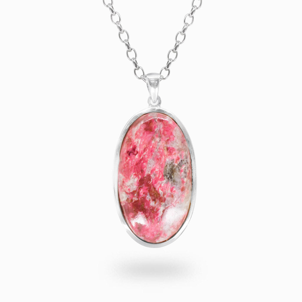 Elongated oval pink Thulite pendant with white and earthy mineral inclusions in a polished 925 sterling silver bezel setting.