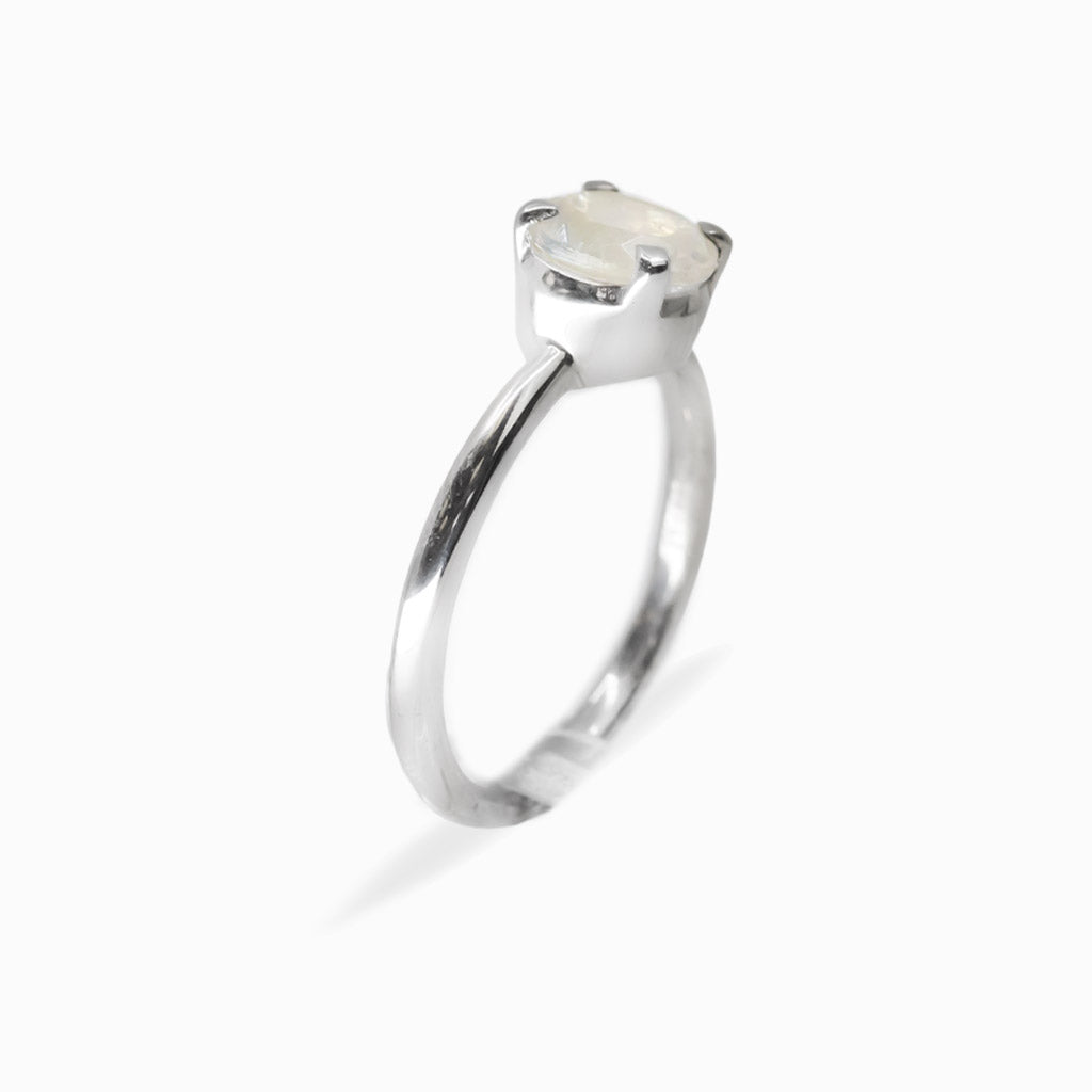Round faceted Rainbow Moonstone ring in polished 925 sterling silver with blue flashes, four-prong setting and slender band.