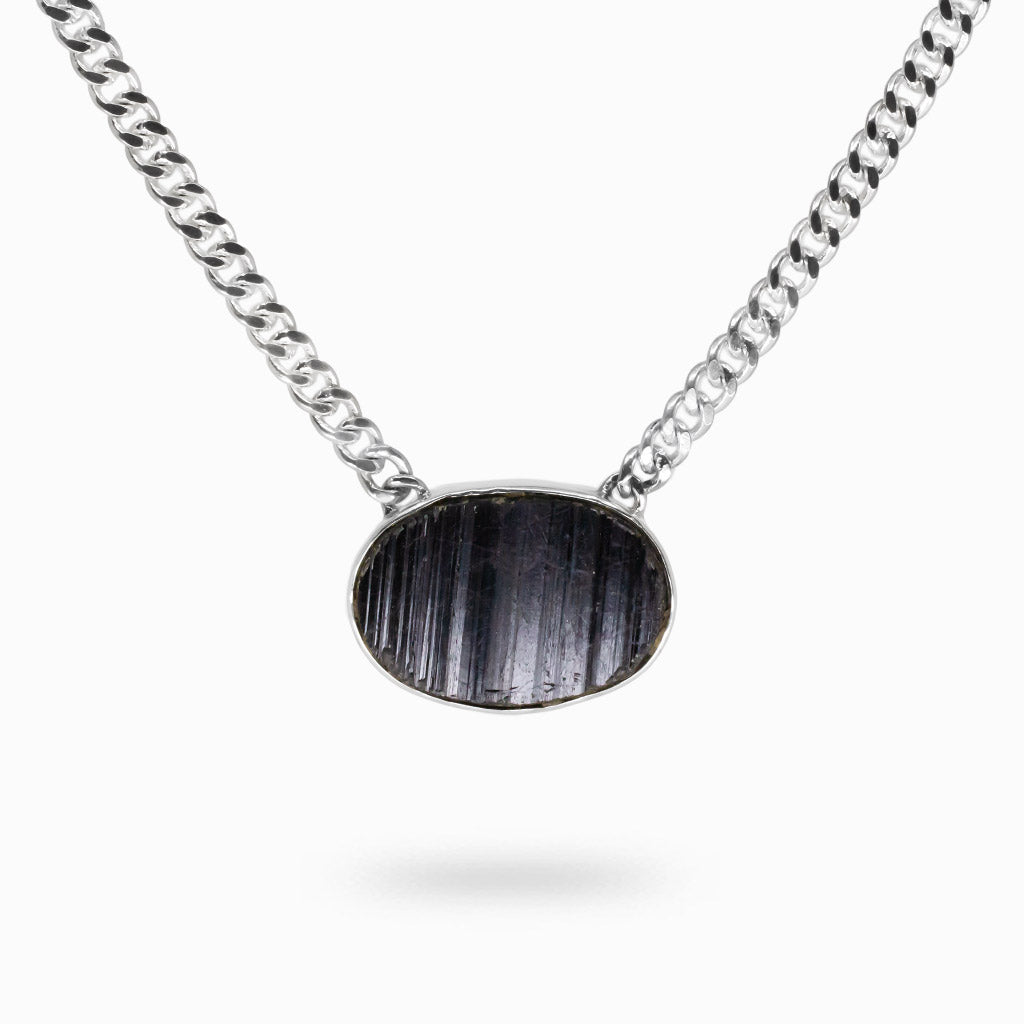 Raw oval black tourmaline pendant with natural vertical striations set in sterling silver with attached silver chain. | MADE IN EARTH 