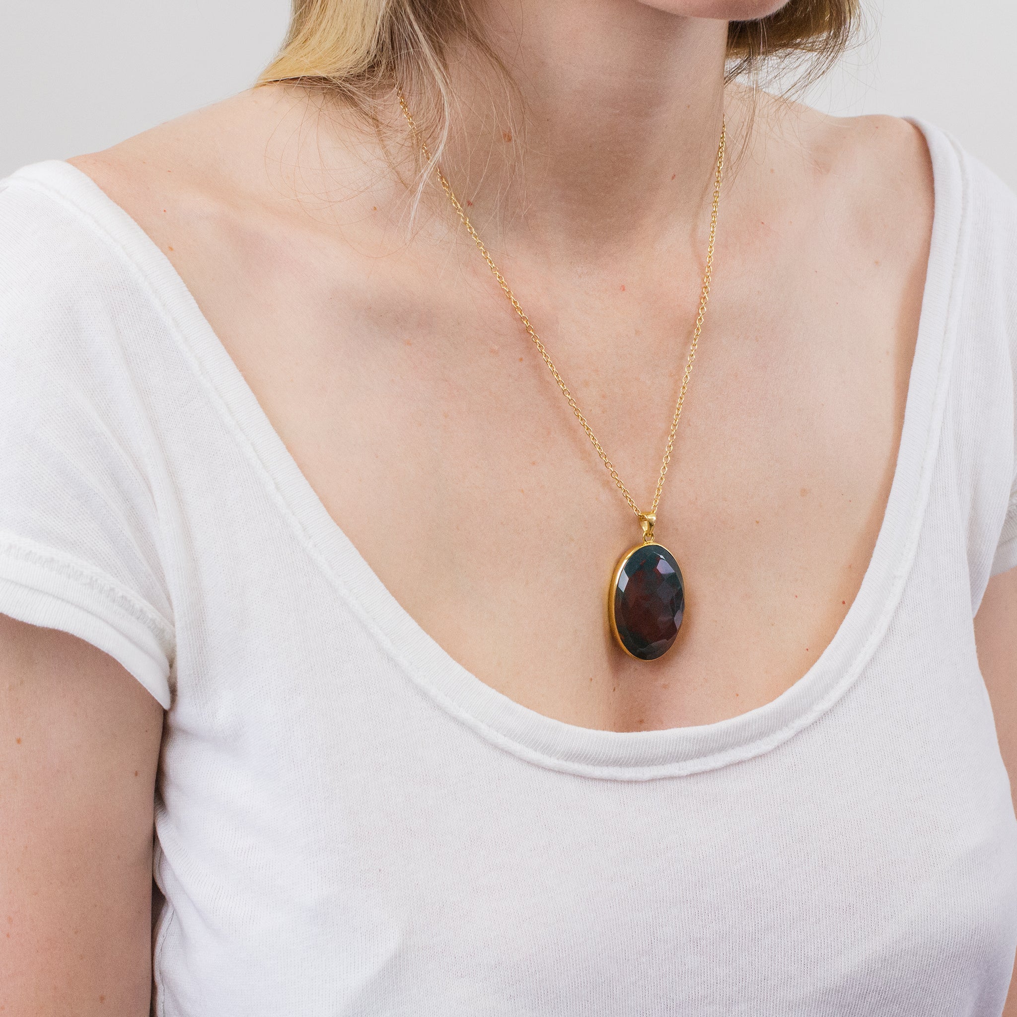 FACETED OVAL BLOODSTONE PENDANT WITH 14K YELLOW GOLD VERMEIL FINISH ON MODEL