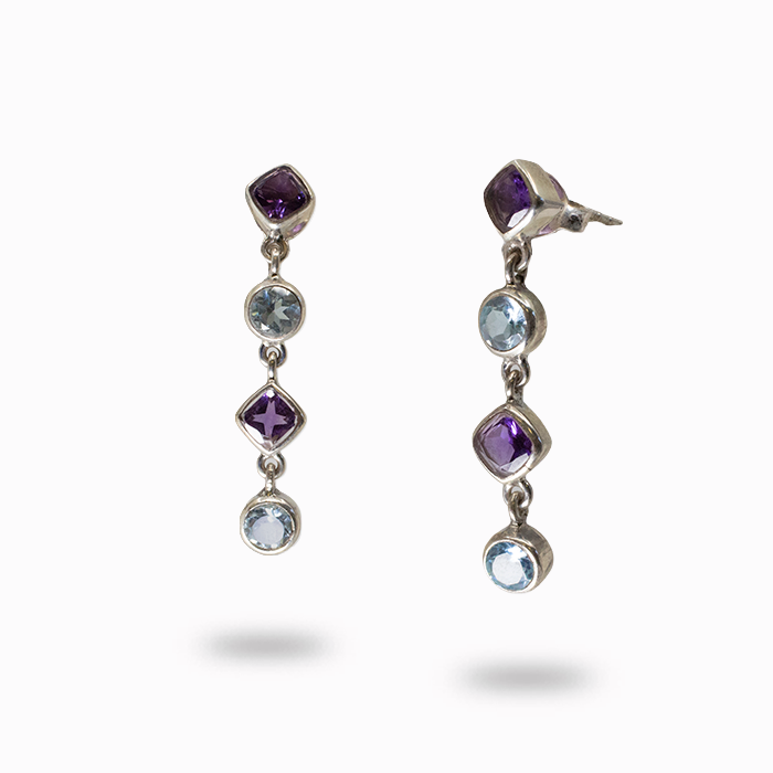 Pair of silver earrings with gemstones on a white background