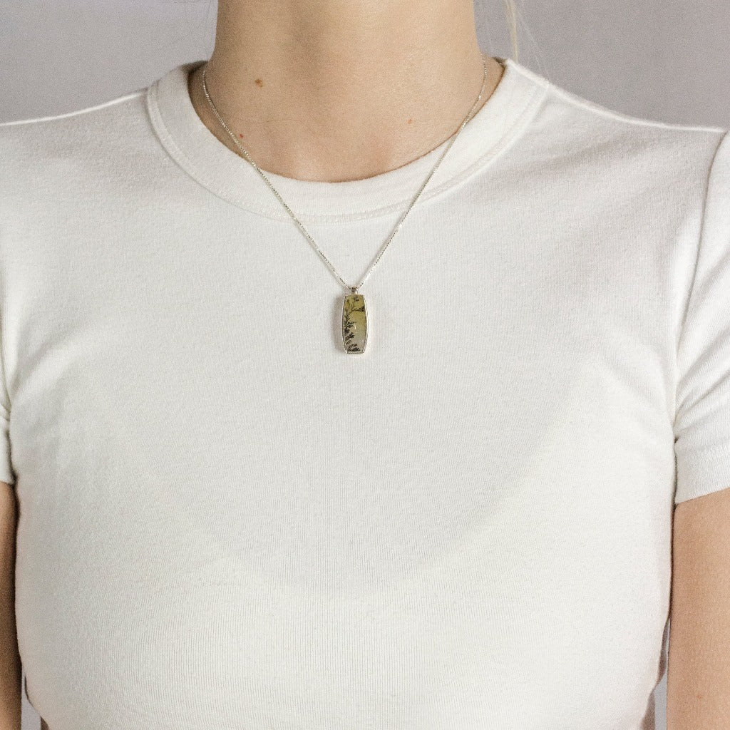 Rounded vertical rectangle yellow with dendritic fern like black structures Dendritic Quartz necklace made in earth On Model